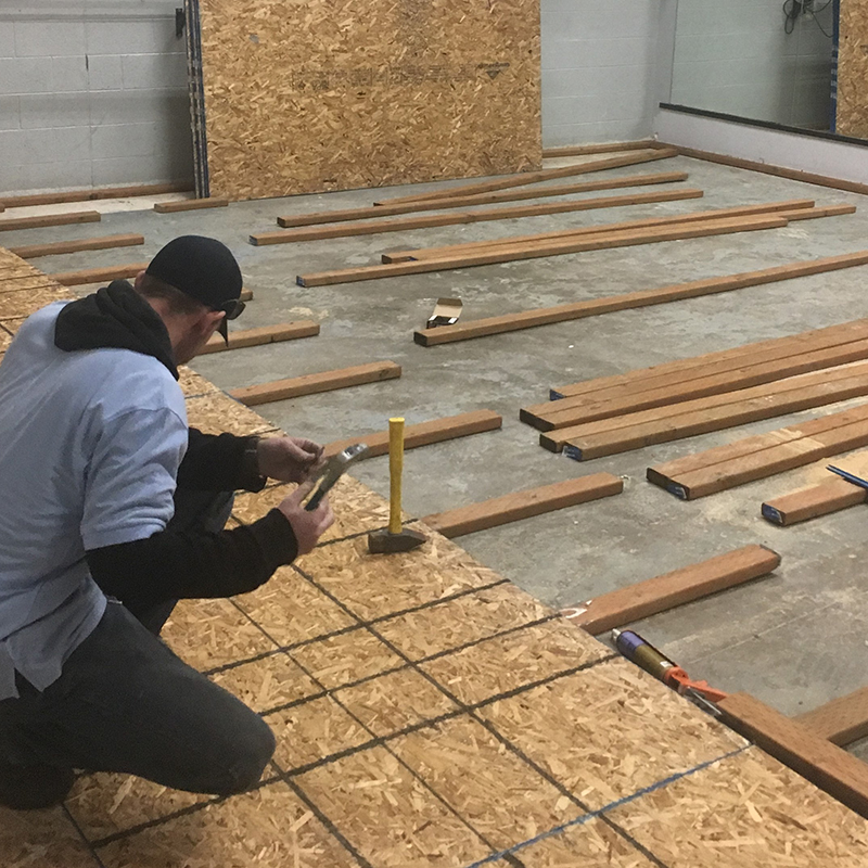 Man building on the floor with plywood.