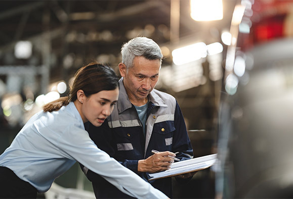 Business man and woman, pointing and discussing in a warehouse