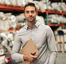 Business man in a warehouse that needs cleaning services from RBM.