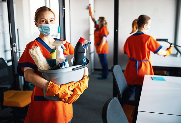 Ladies performing janitorial services in an office to make it clean.